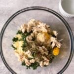chicken, spinach, cheeses, eggs and spices in a bowl.