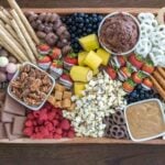 treats and fruit on a dessert snack board.
