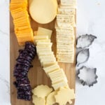 different types of cheeses on a cutting board.