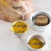 ham, orange juice, brown sugar and mustard on a table.