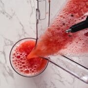 pink liquid being poured from a blender.