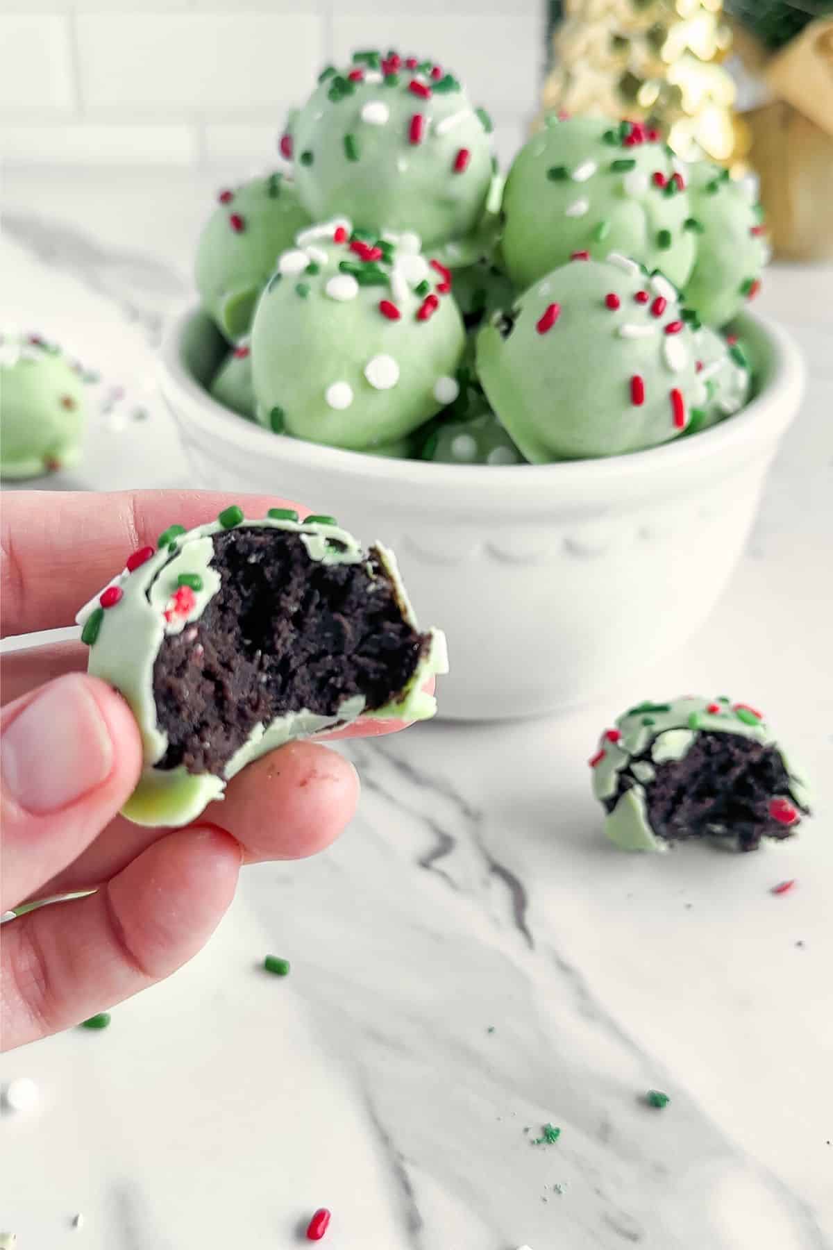 Bowl of grinch balls with a bite out of one.