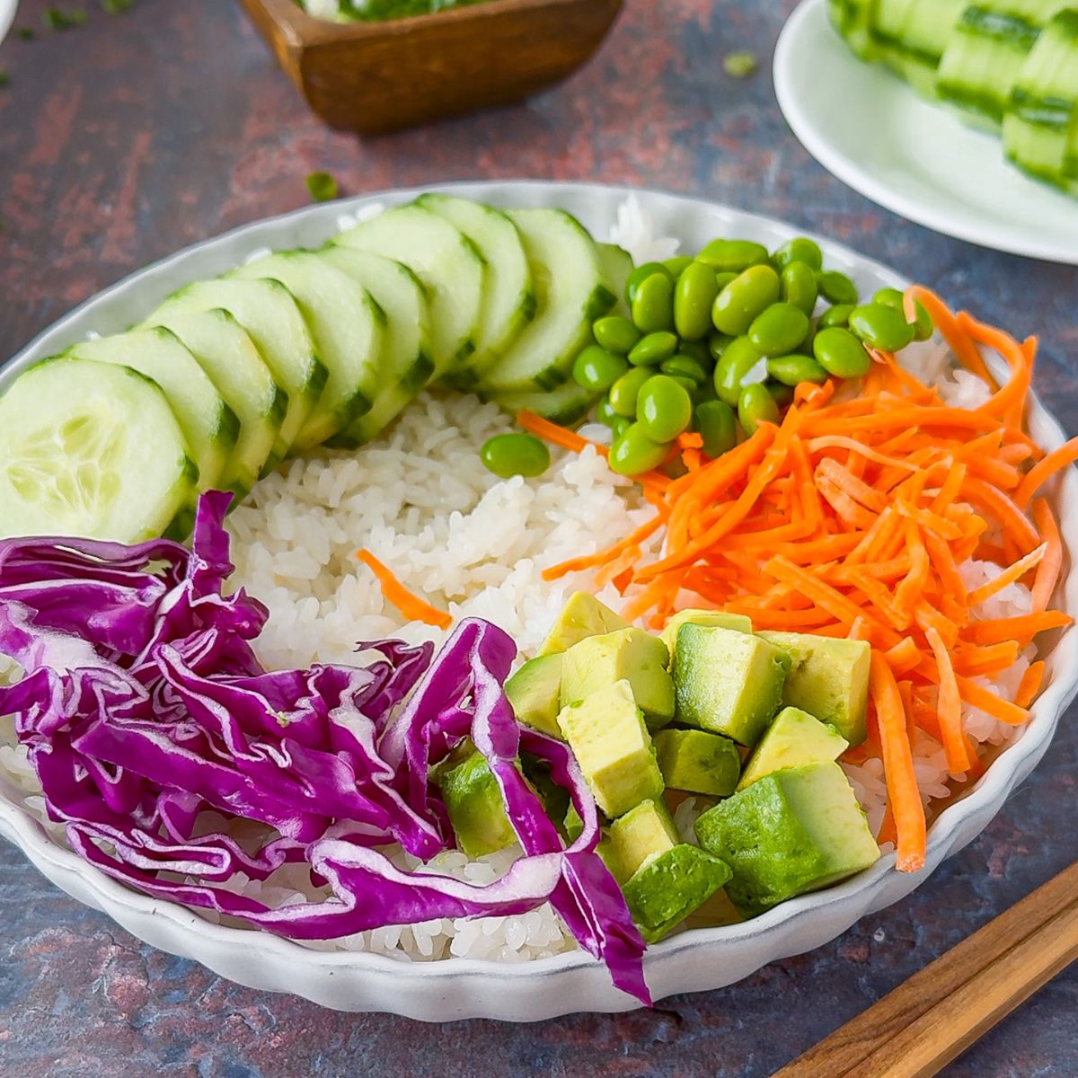 Assembling Salmon bowl with veggies.
