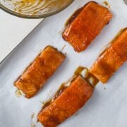 Adding the marinated salmon on the baking sheet.