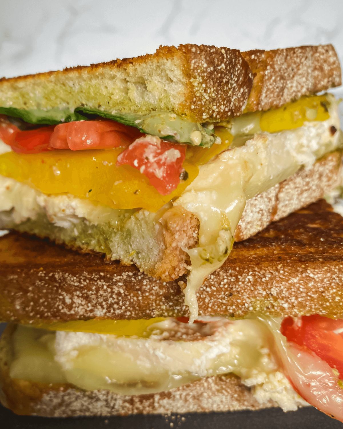 a stack of chicken pesto panini sandwiches.