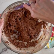 Scraping the sides of the bowl after adding the cocoa powder.