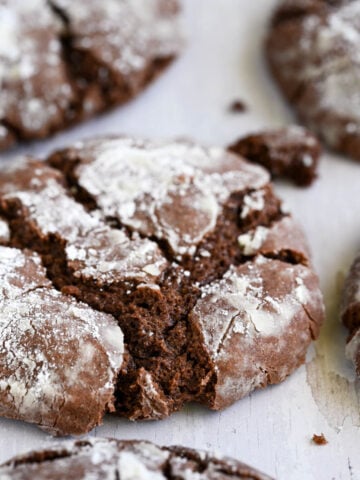 Chocolate crinkle cookies on a sheet pan.