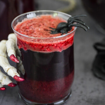 Glass of halloween punch with a skeleton hand.