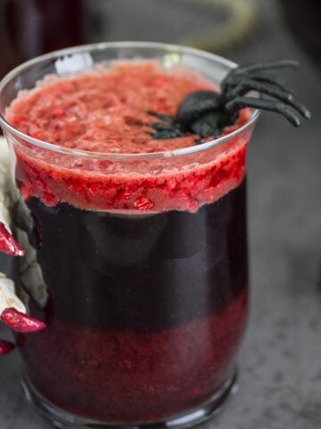 Glass of halloween punch with a skeleton hand.