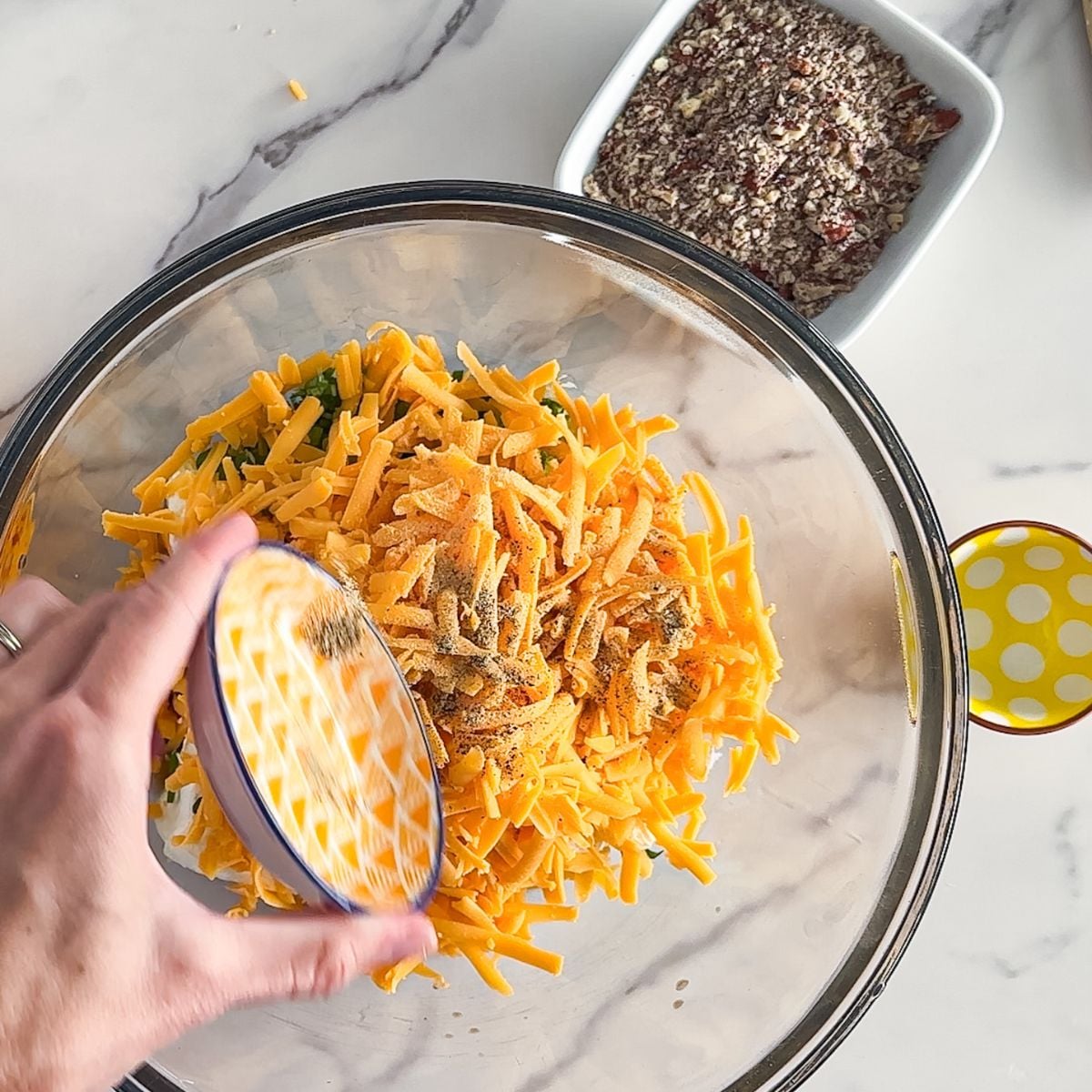 Adding spices and other ingredients to a bowl.