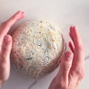 Forming the cheese bal in plastic wrap.