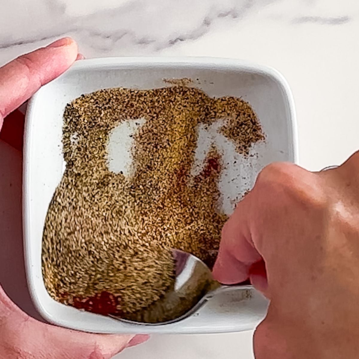 Mixing philly cheesesteak seasoning.