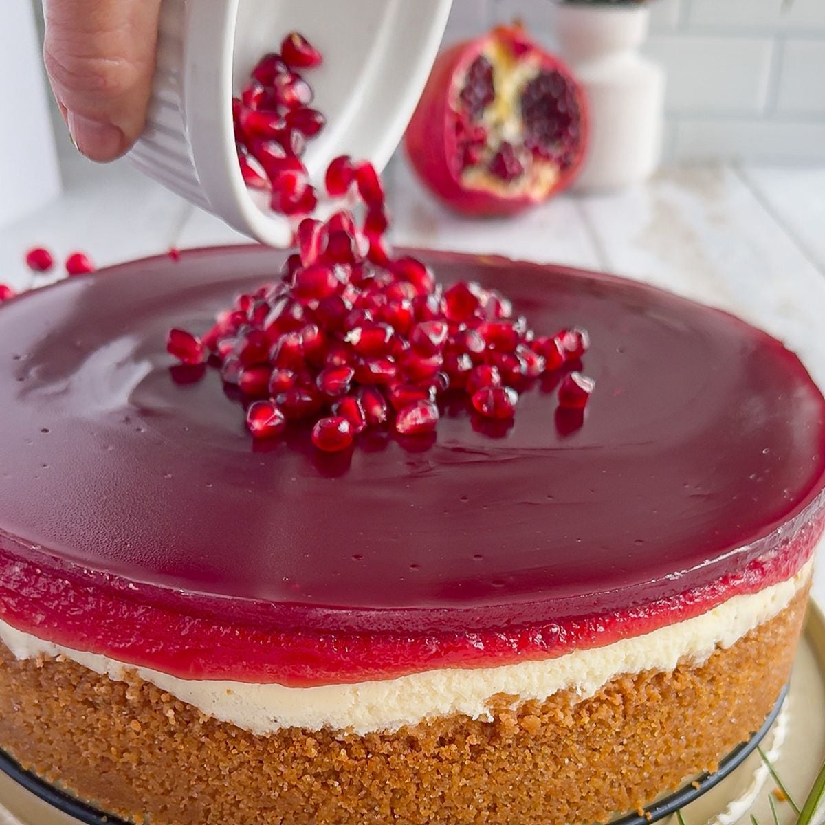 Topping the cooled cheesecake with my pomegranates.
