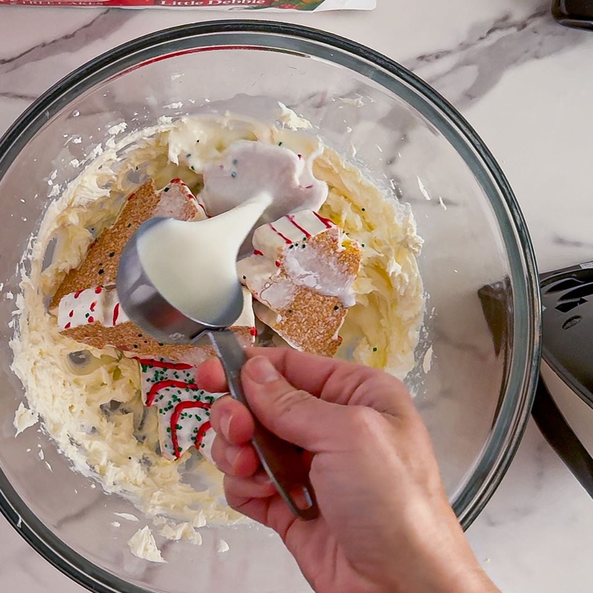 Adding in Little Debbie Christmas trees into the dip.