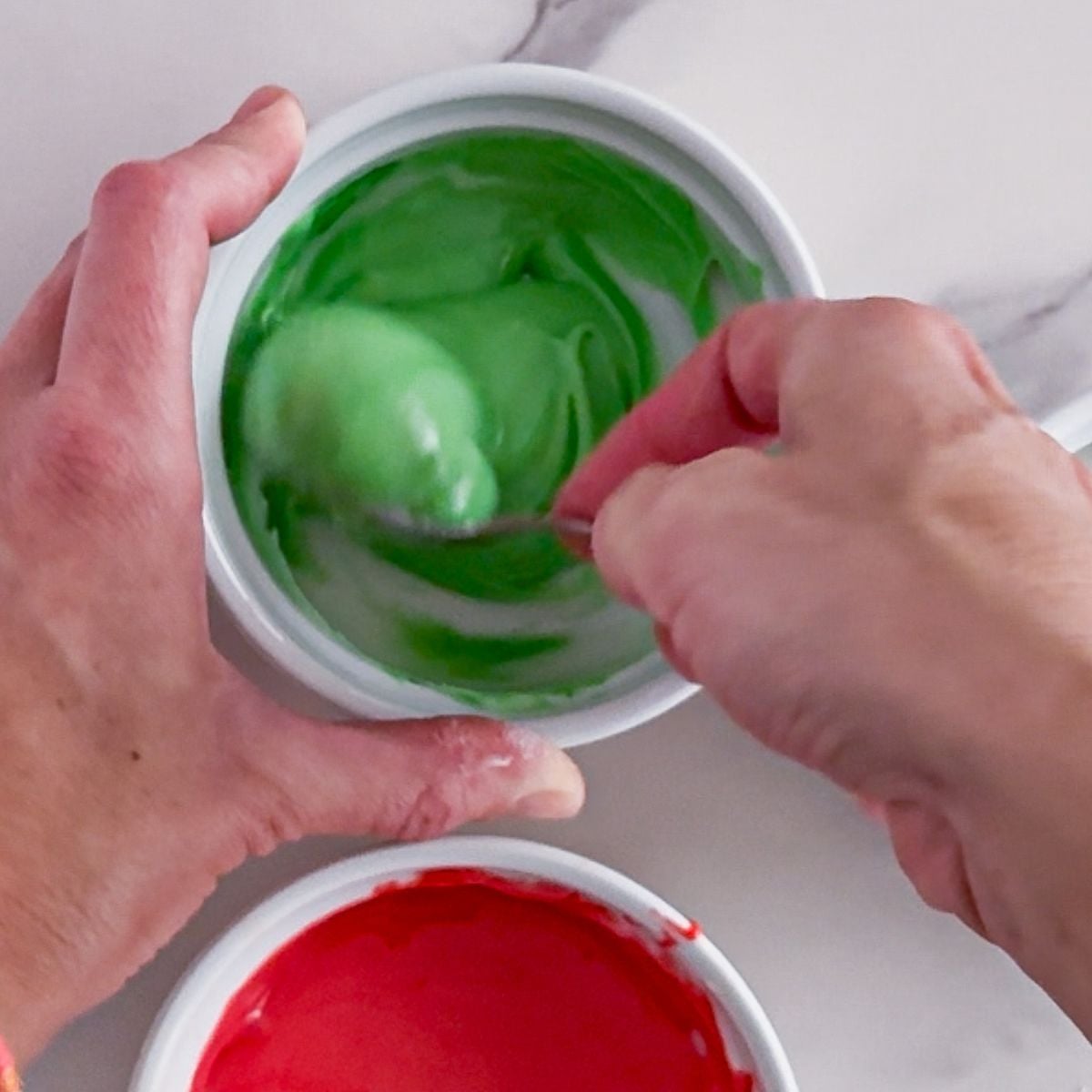 Adding dye to sugar cookie icing.