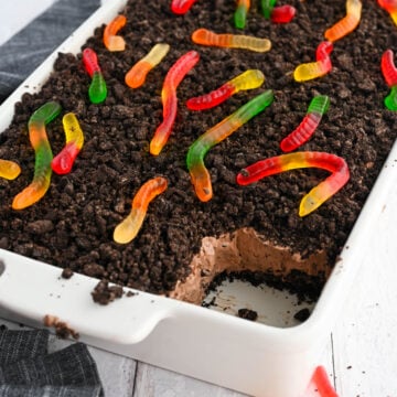 Tasty dirt cake with gummy worms on top.
