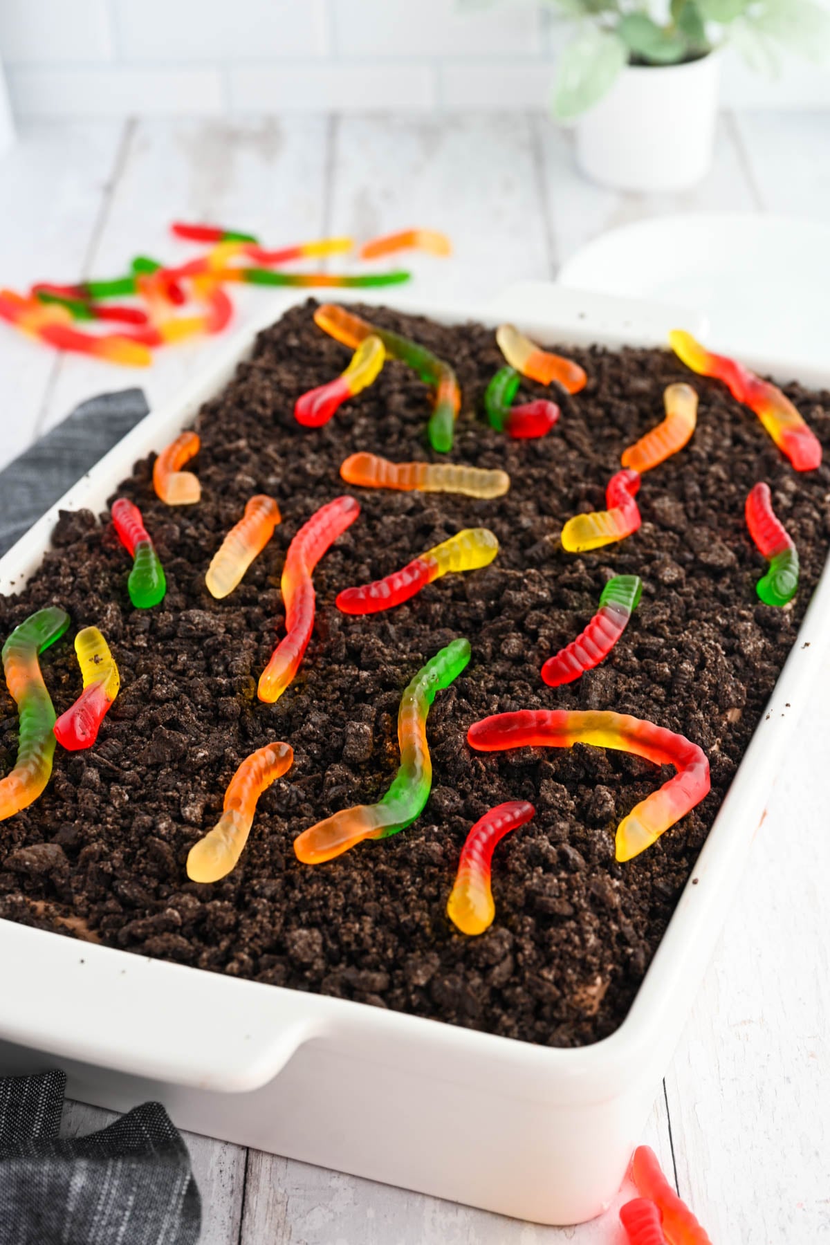 Tasty dirt cake with gummy worms on top.