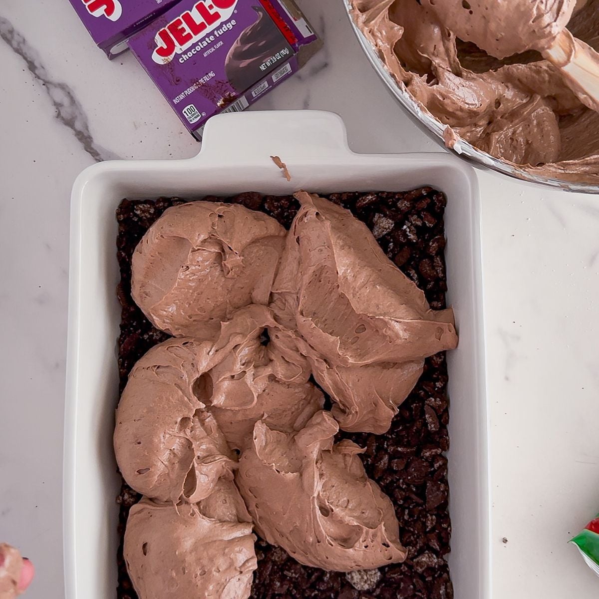 Adding the pudding to the crushed oreos.