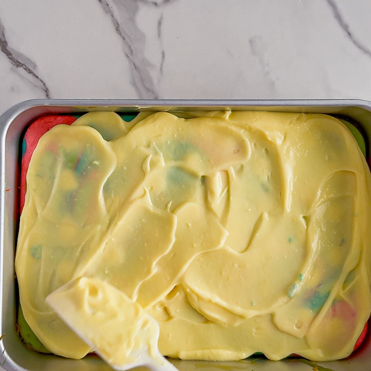 Spreading pudding on poke cake.