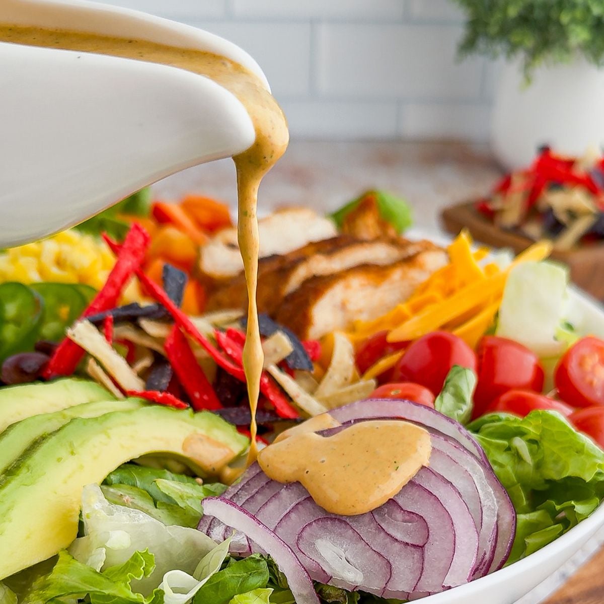 Pouring the dressing on the southwest salad.