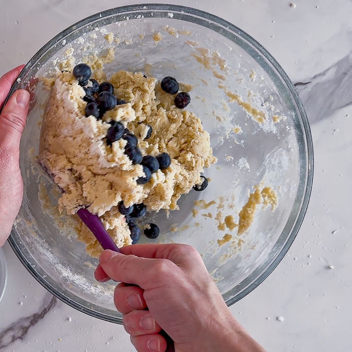 Folding in the blueberries into the cookie dough.