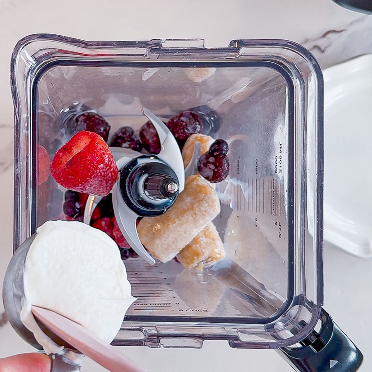 Adding ingredients to a high speed blender. 
