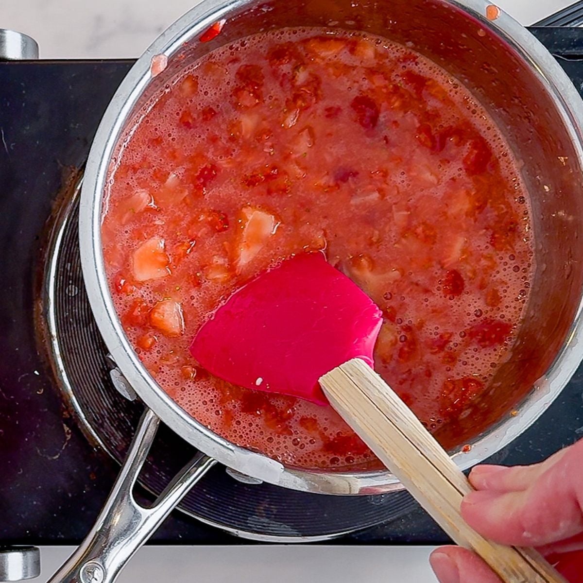 Bringing the strawberries in a pot to a boil.