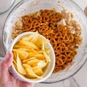 Adding chips and pretzels for kitchen sink cookies.
