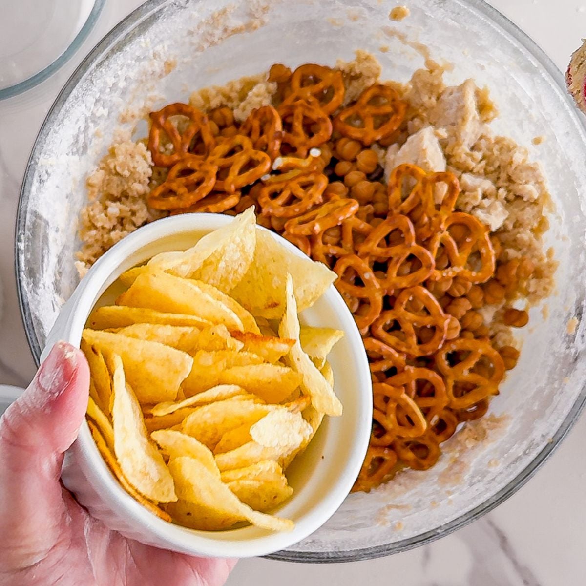 Adding chips and pretzels for kitchen sink cookies.