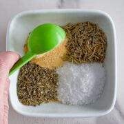 Adding different seasonings to a bowl.