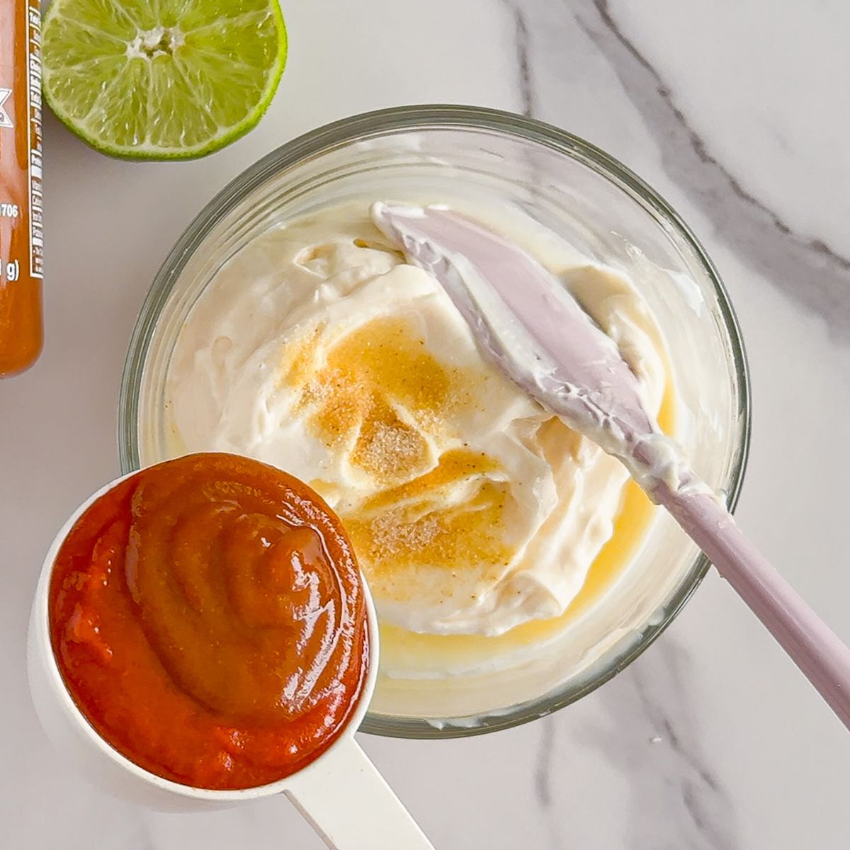 Adding the ingredients in a bowl for sriracha mayo.