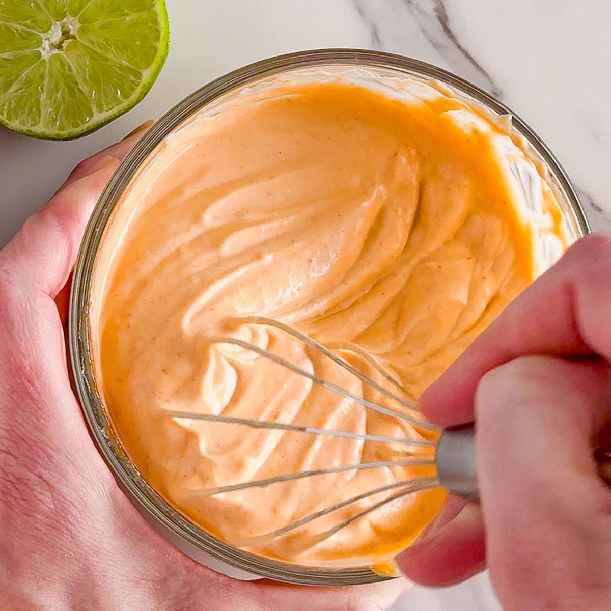Whisking sriracha mayo.